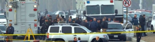 A group of first responders stand outside a mobile command center