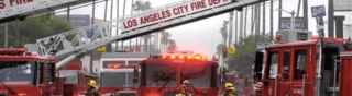 Los Angeles City Fire trucks with block a street with ladders extended
